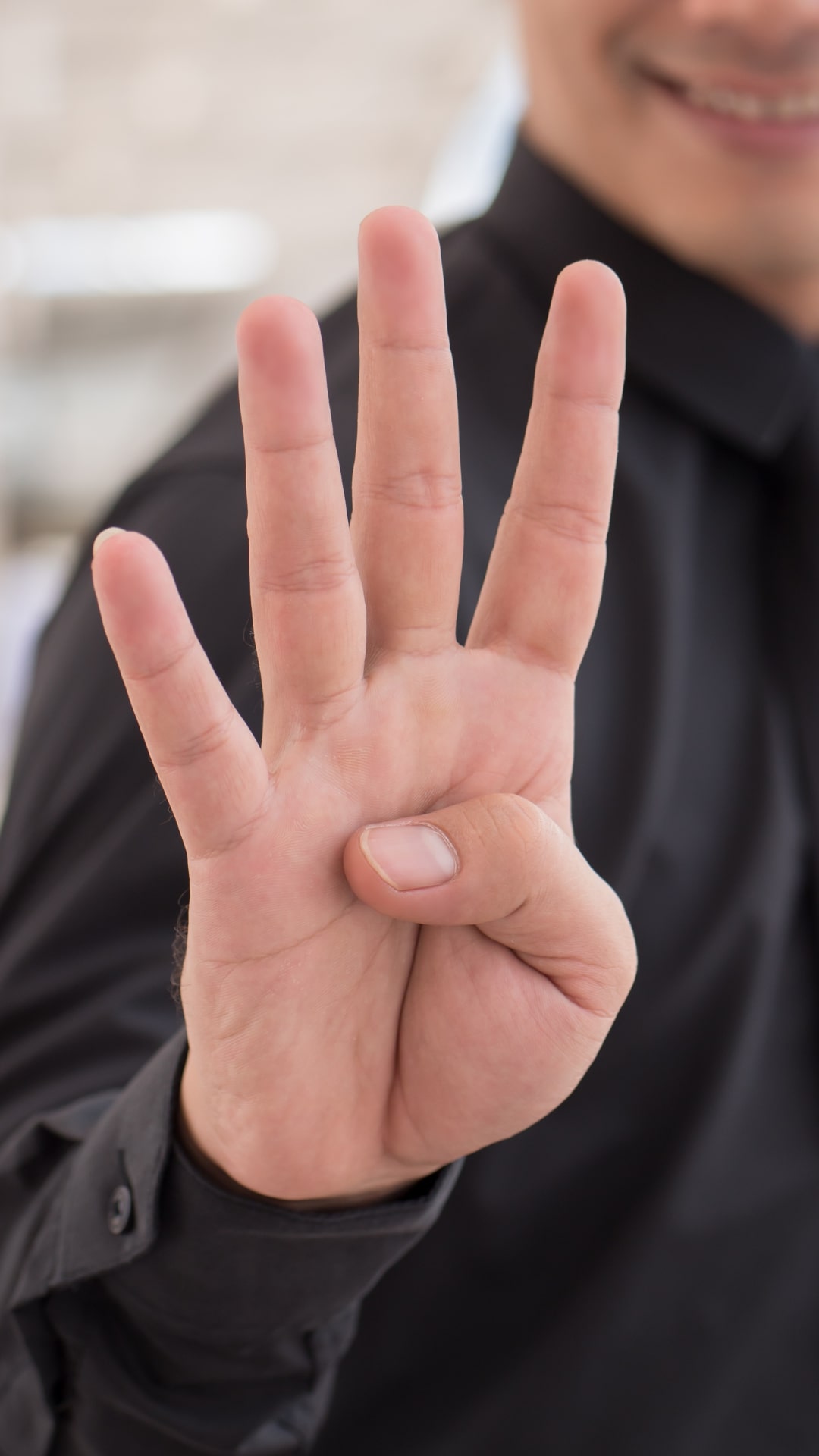 Close Up on Person’s Hand Counting Four